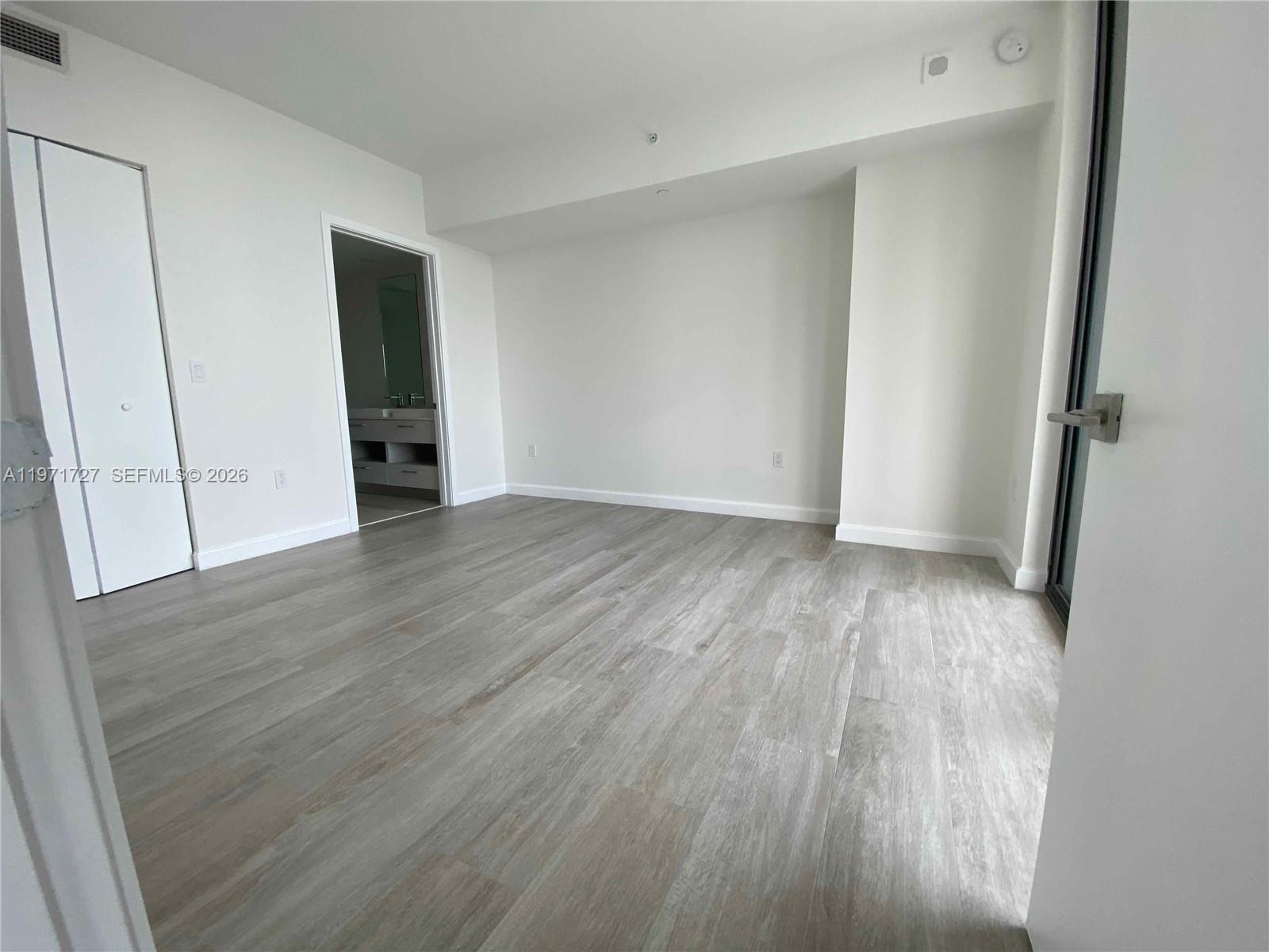 45 Southwest 9th Street, Unit 3703 Miami, FL 33130 - Photo 26 of 73 a view of an empty room with wooden floor and closet
