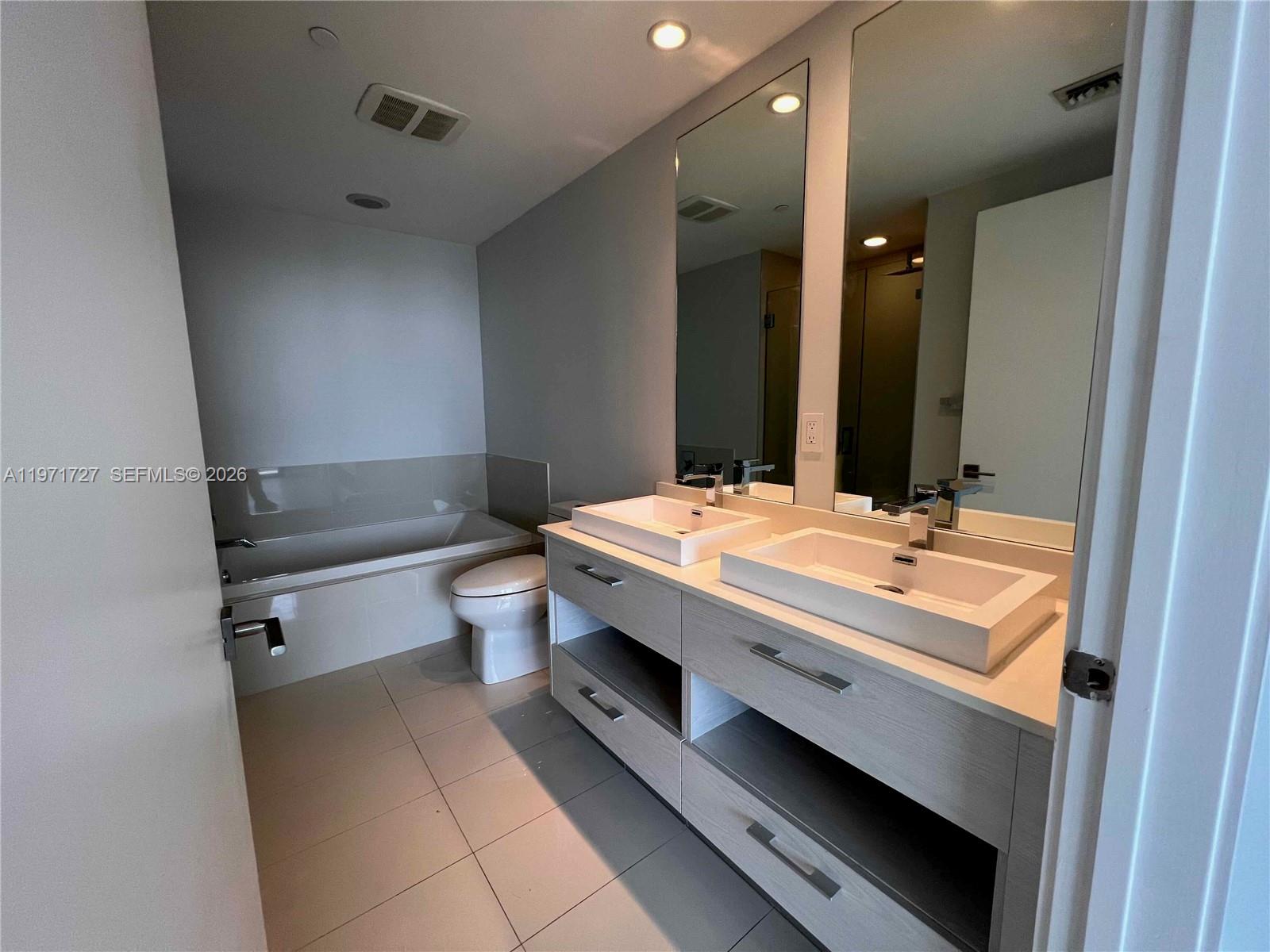 45 Southwest 9th Street, Unit 3703 Miami, FL 33130 - Photo 30 of 73 a bathroom with a double vanity sink toilet and mirror