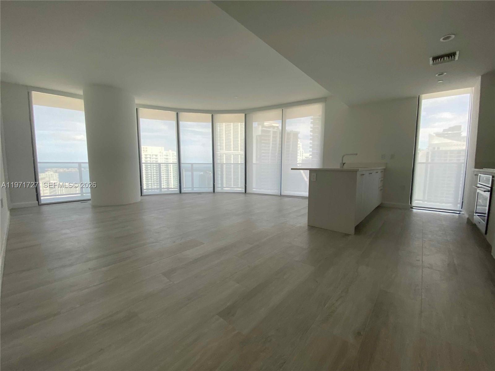 45 Southwest 9th Street, Unit 3703 Miami, FL 33130 - Photo 3 of 73 an empty room with wooden floor and windows