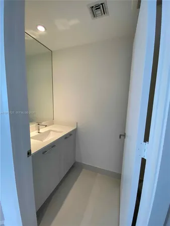a bathroom with a sink a toilet a mirror and shower