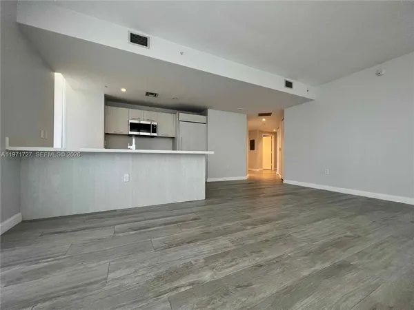 a view of a kitchen with microwave and cabinets