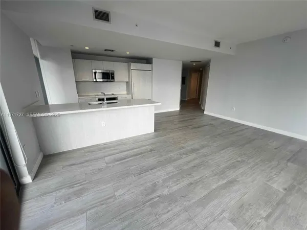 a kitchen with stainless steel appliances granite countertop a sink cabinets and wooden floor