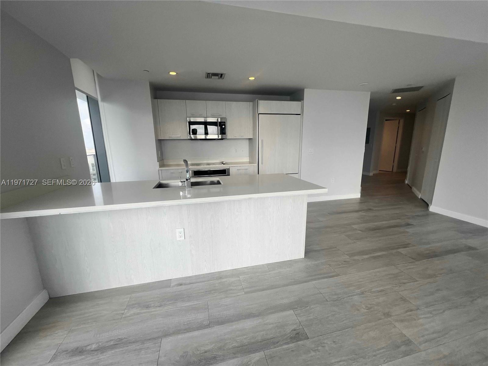 45 Southwest 9th Street, Unit 3703 Miami, FL 33130 - Photo 7 of 73 a kitchen with stainless steel appliances a refrigerator sink and cabinets