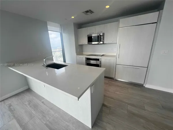 a kitchen with stainless steel appliances a refrigerator and a sink