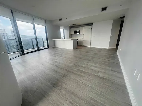 a view of a refrigerator in kitchen and a window