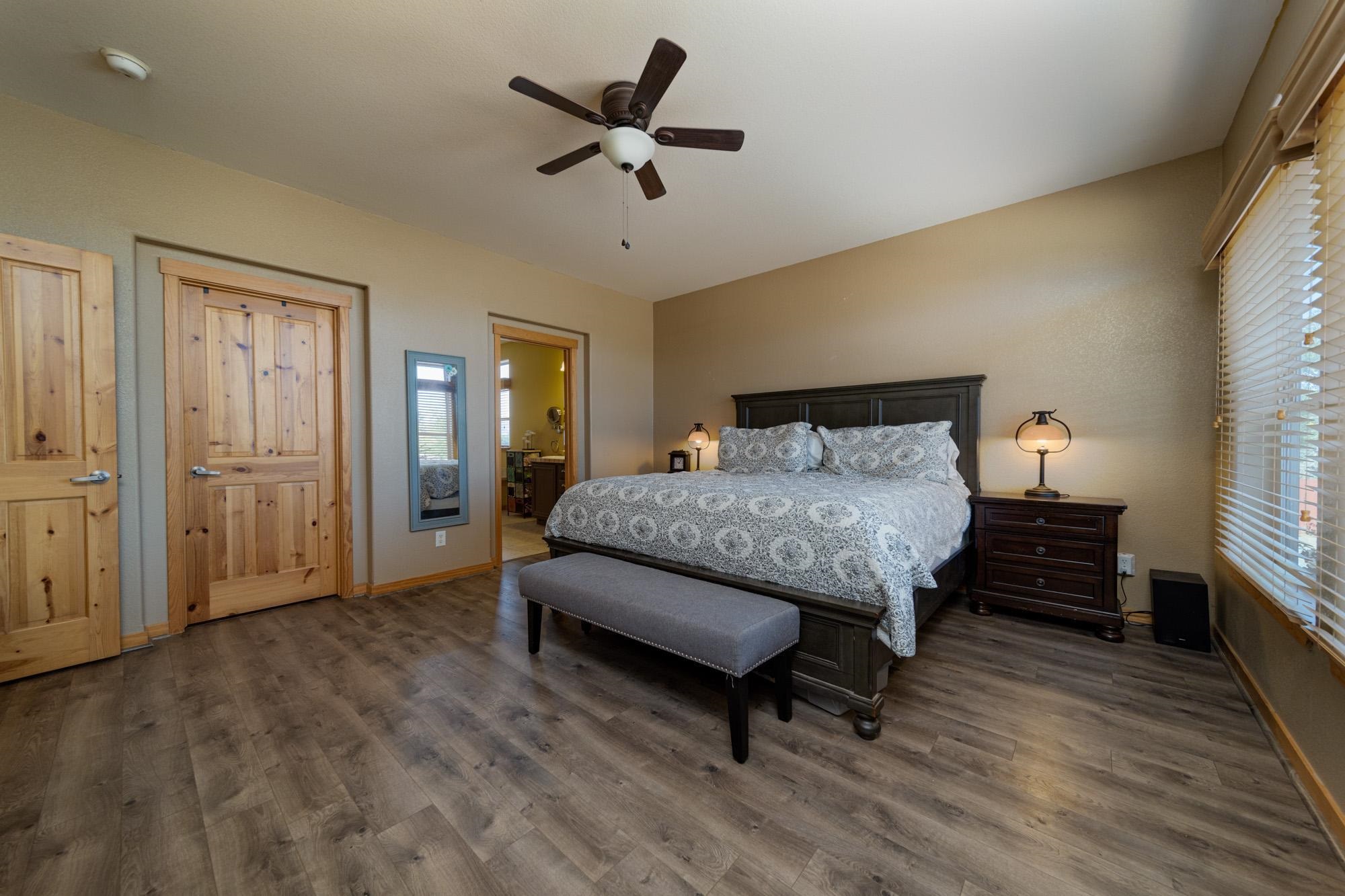 1745 North 3/10 Road Fruita, CO 81521 - Photo 14 of 41 a spacious bedroom with a bed and a ceiling fan