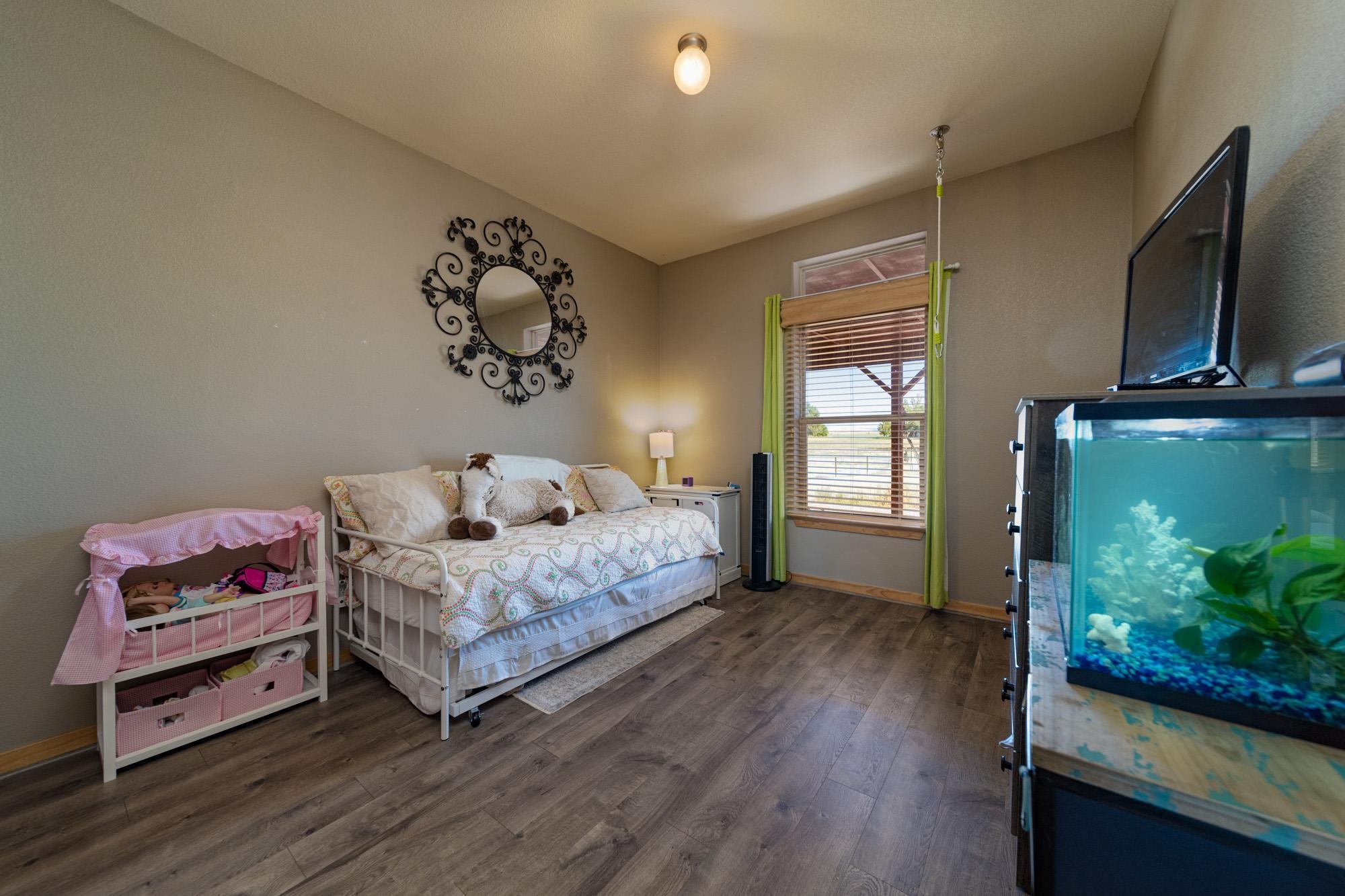1745 North 3/10 Road Fruita, CO 81521 - Photo 23 of 41 a bedroom with a bed and flat screen tv