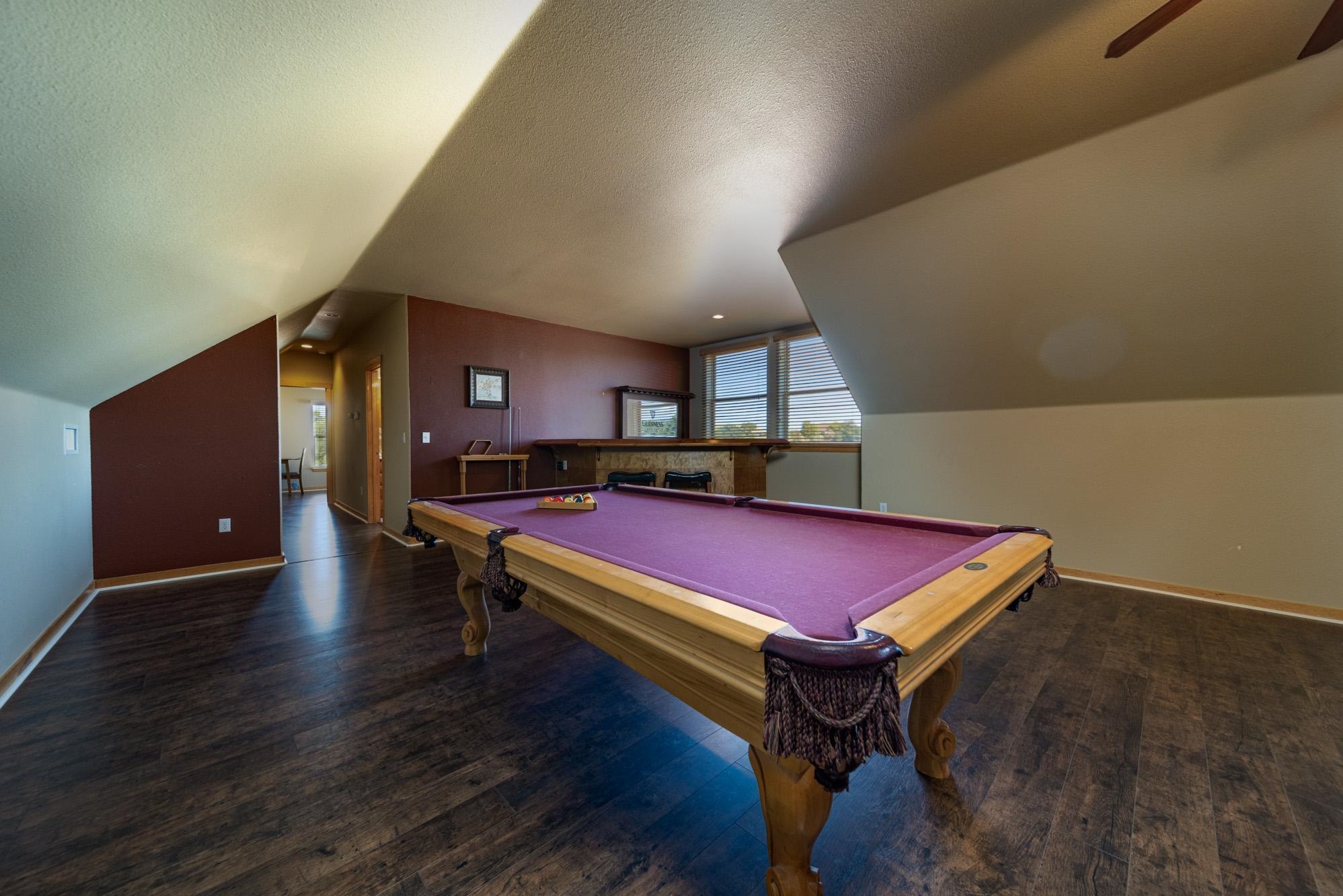 1745 North 3/10 Road Fruita, CO 81521 - Photo 27 of 41 a room with pool table wooden floor and windows