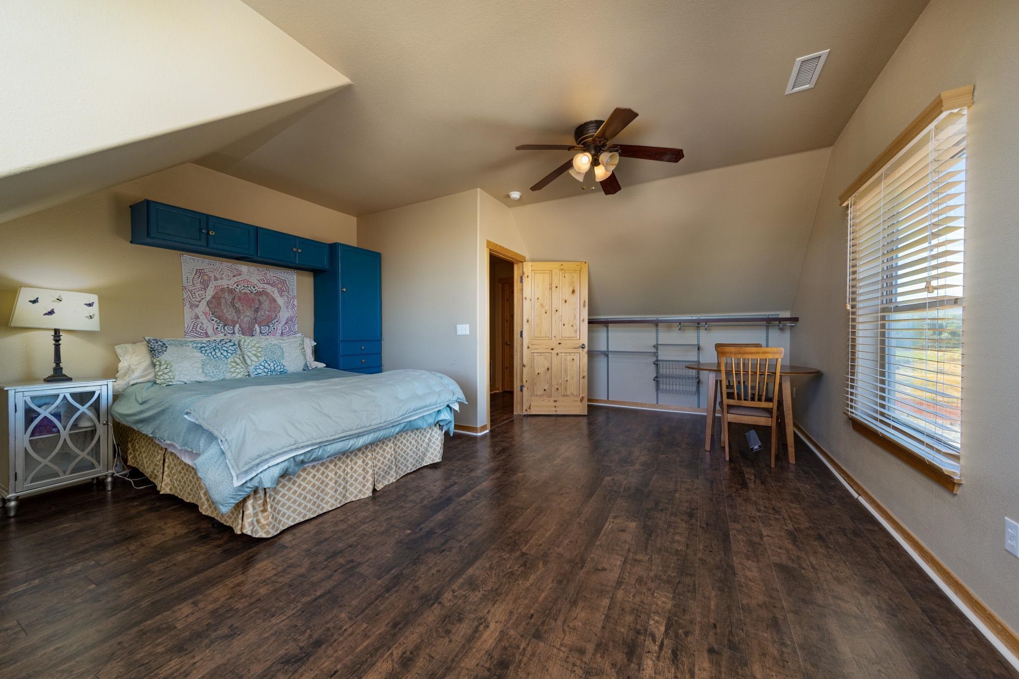 1745 North 3/10 Road Fruita, CO 81521 - Photo 30 of 41 a bedroom with a bed wooden floor and window
