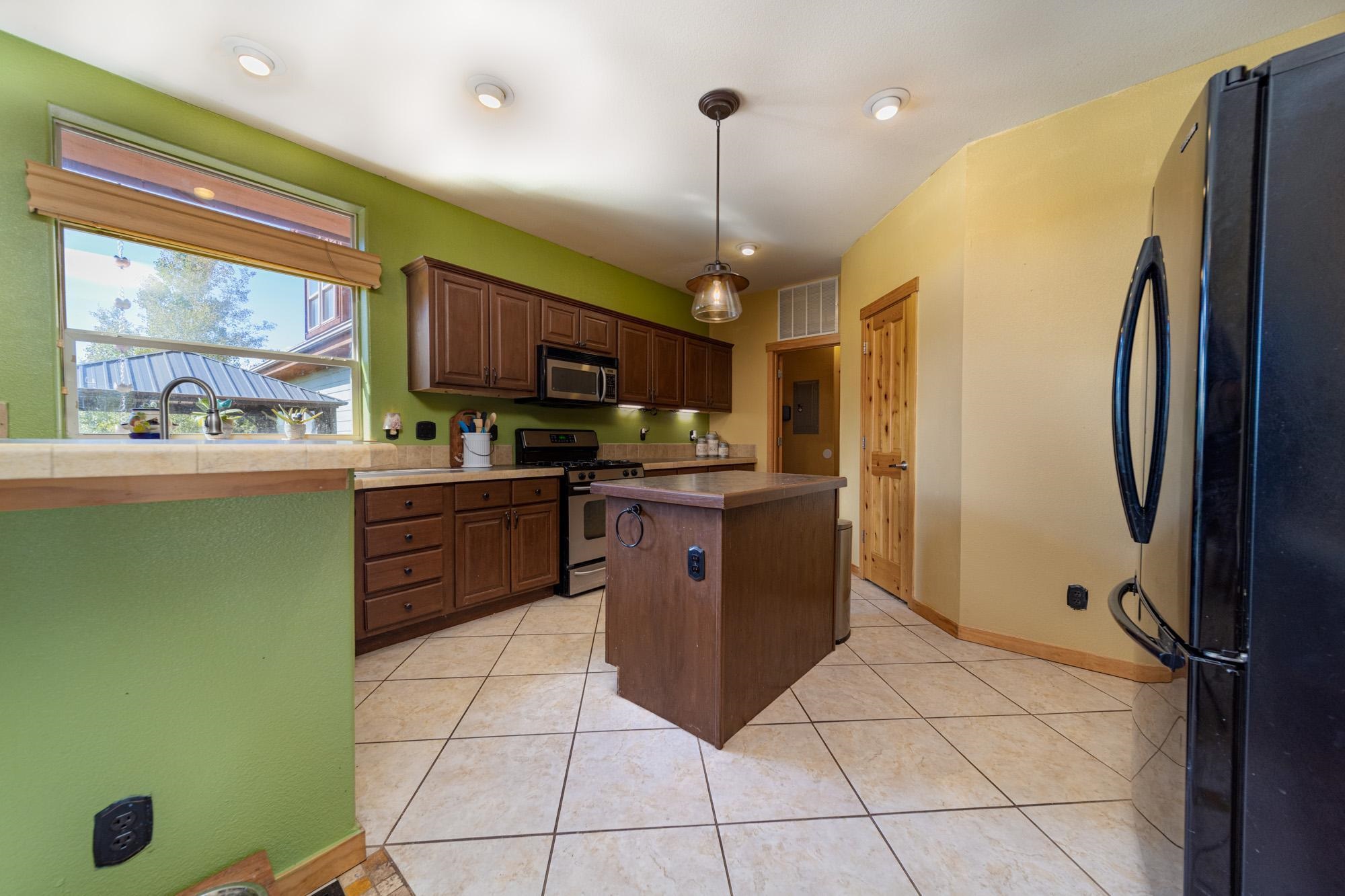 1745 North 3/10 Road Fruita, CO 81521 - Photo 8 of 41 a kitchen with stainless steel appliances granite countertop a refrigerator a sink and a stove