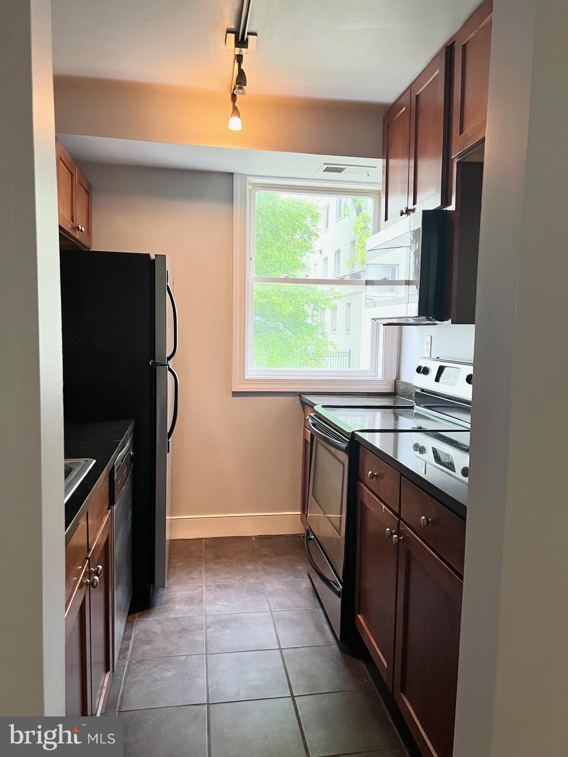 2841 Gainesville Street Southeast, Unit 203 Washington, DC 20020 - Photo 8 of 12 a kitchen with stainless steel appliances a stove sink and refrigerator