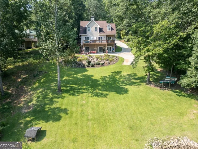 a front view of a house with a yard and large trees