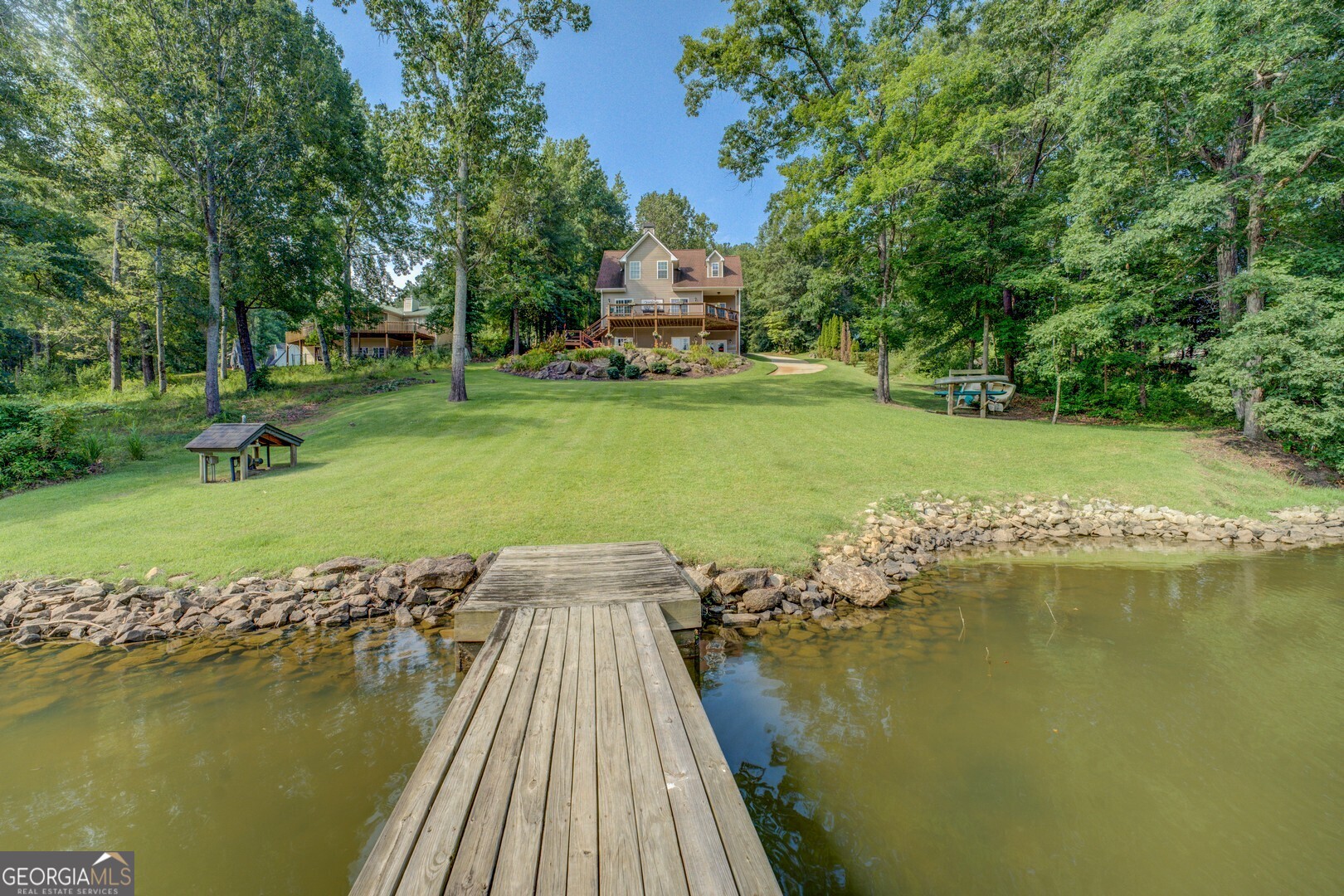 734 Raven Road Monticello, GA 31064 - Photo 29 of 81 a view of a lake with a yard and large trees