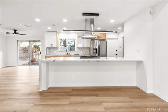 a large kitchen with kitchen island a stove a counter space and a sink