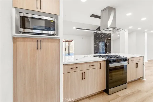 a kitchen with stainless steel appliances granite countertop a stove and a microwave