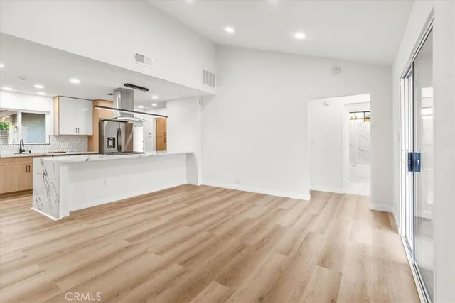 a view of a kitchen with wooden floor and windows