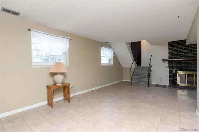 an empty room with fireplace and windows