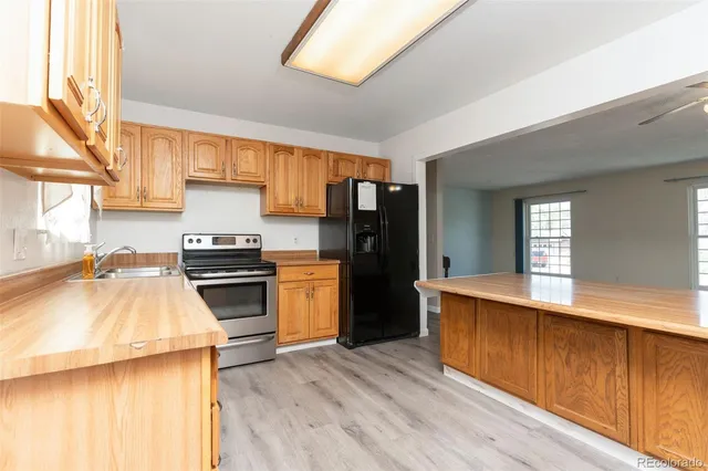 a kitchen with a sink a counter top space and stainless steel appliances