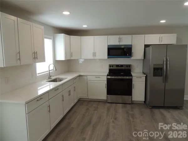 a kitchen with a sink a stove a refrigerator and cabinets