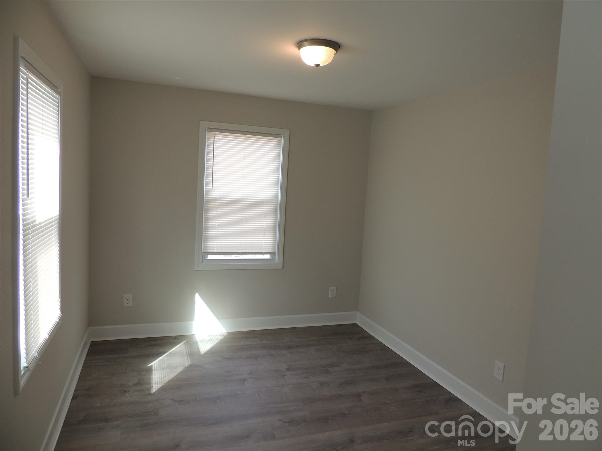 146 Loomis Street Chester, SC 29706 - Photo 6 of 12 an empty room with wooden floor and windows