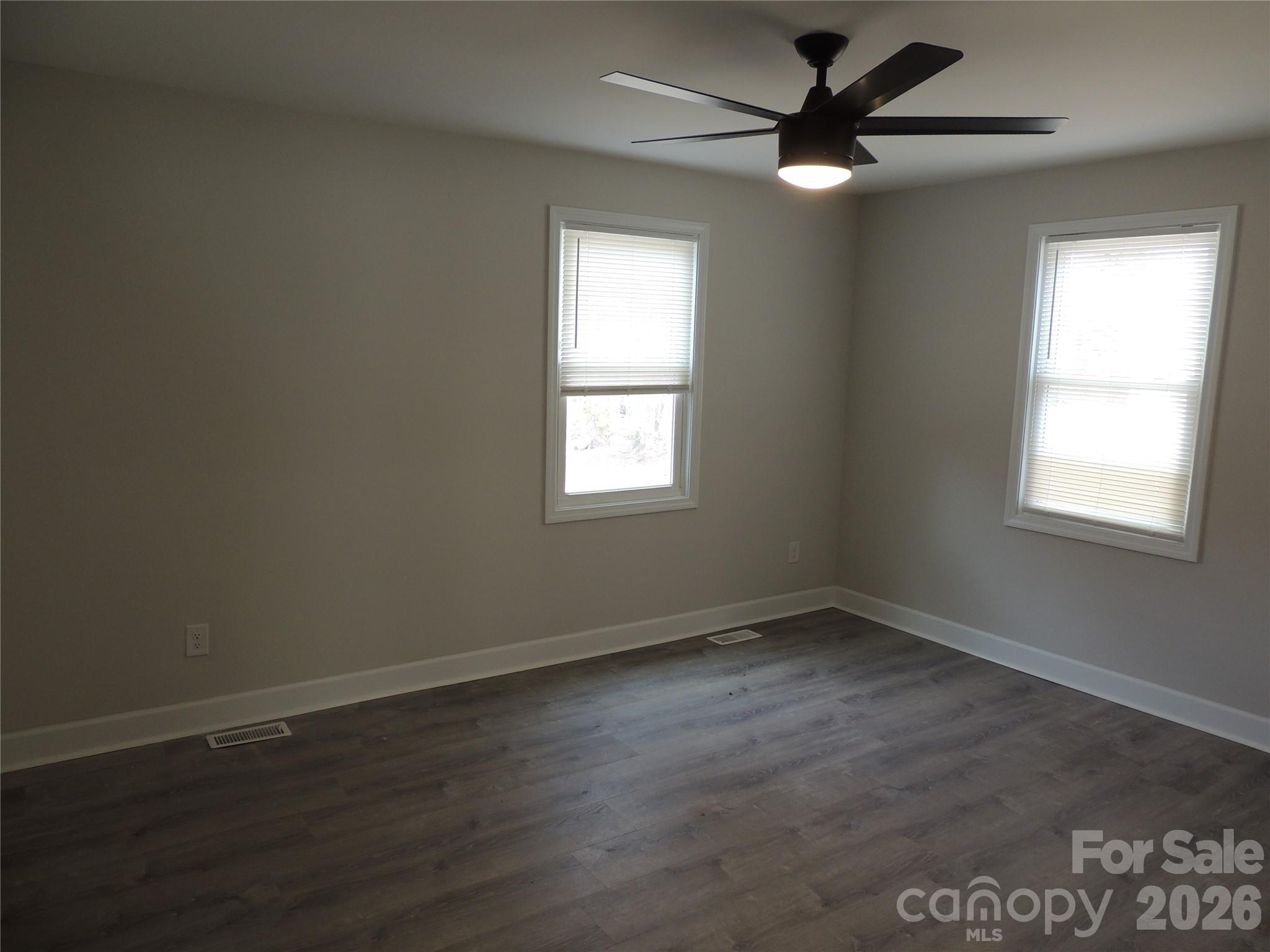 146 Loomis Street Chester, SC 29706 - Photo 9 of 12 an empty room with wooden floor and windows