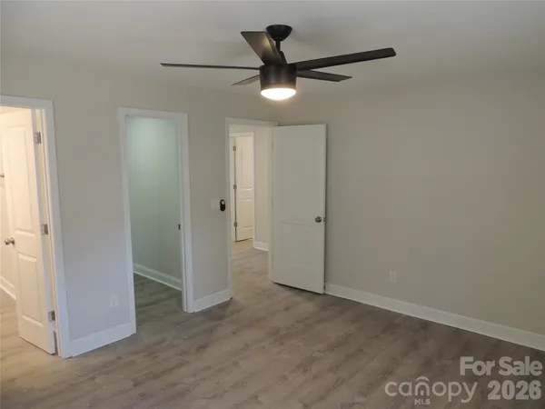 an empty room to ceiling fan and closet area