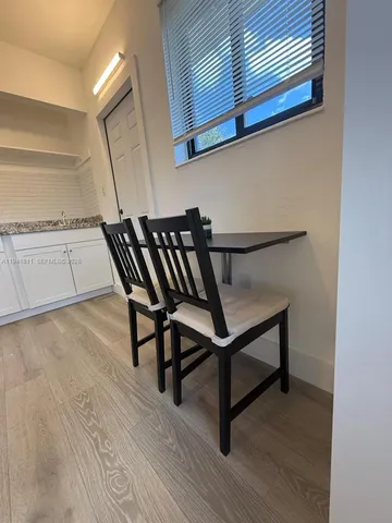 a view of a hallway with wooden floor and a cabinet