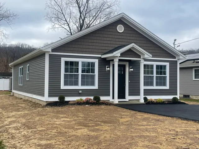 a front view of a house with a yard and glass windows
