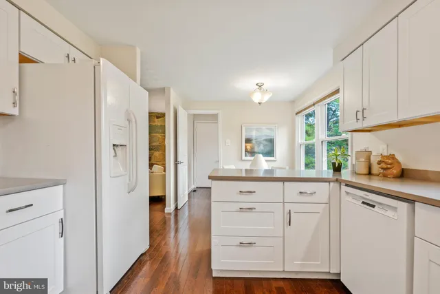 a kitchen with white cabinets and refrigerator