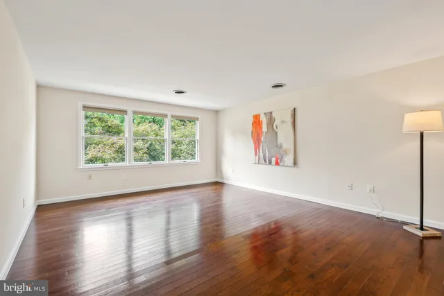 an empty room with wooden floor and window
