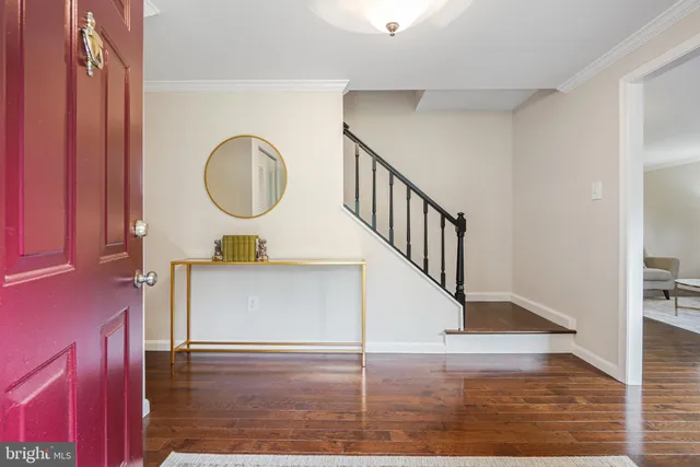 a view of a hallway with wooden floor and staircase