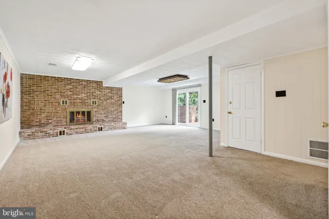 a view of a livingroom with an empty space and a fireplace