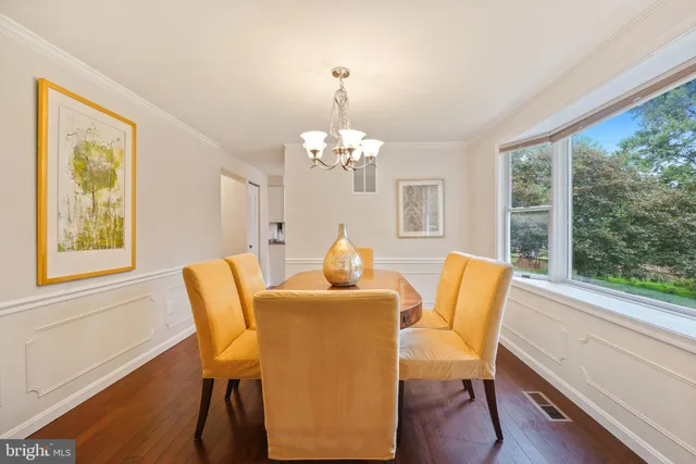 a dining room with furniture a large window and wooden floor