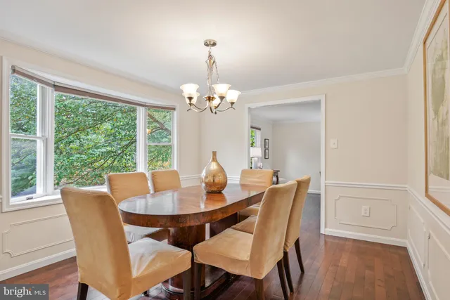 a dining room with furniture a large window and wooden floor