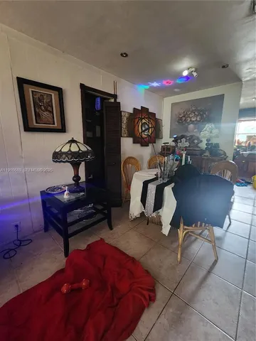 a living room with furniture a rug and white walls