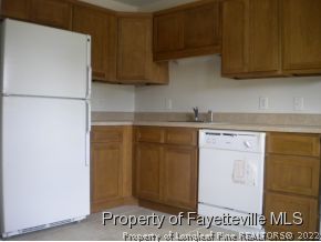 3327 Arrowhead Road Spring Lake, NC 28390 - Photo 3 of 17 a kitchen with stainless steel appliances granite countertop a refrigerator a stove and a sink with wooden cabinets