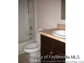 3327 Arrowhead Road Spring Lake, NC 28390 - Photo 10 of 17 a bathroom with a granite countertop toilet and a sink