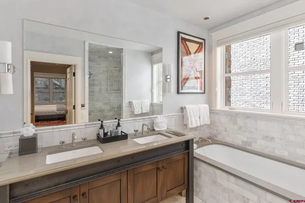 a bathroom with a granite countertop bathtub next to a window