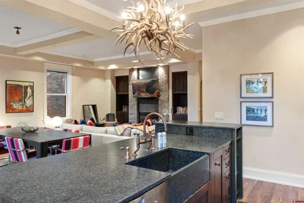 a kitchen with kitchen island granite countertop a sink a counter top space and living room view