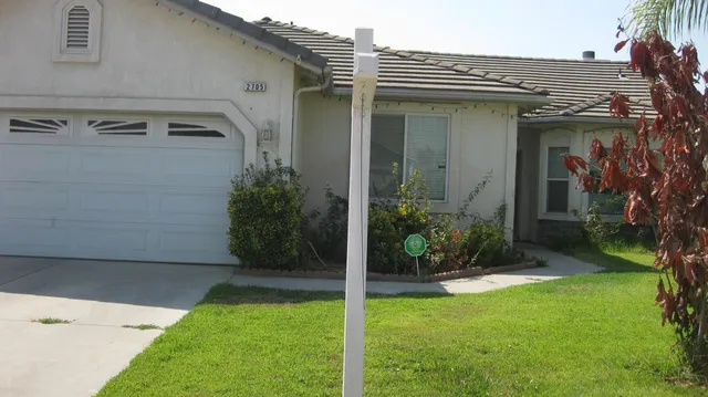 a view of a house with brick walls and a yard with potted plants