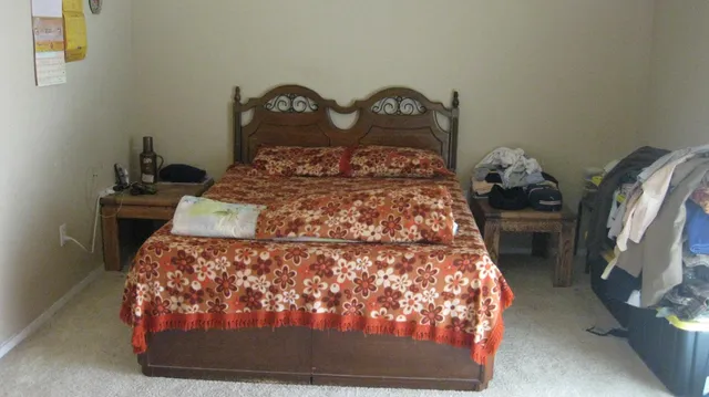 a bed sitting in a bedroom next to a lamp