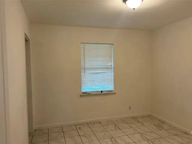 an empty room with white walls and windows