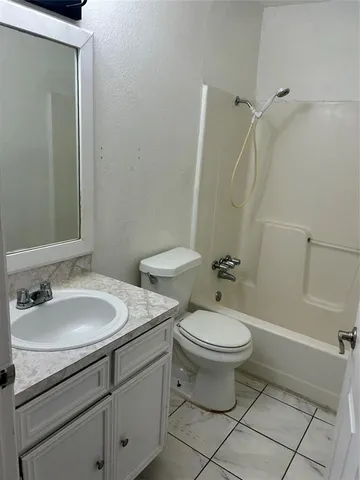 a bathroom with a granite countertop toilet a sink and a mirror