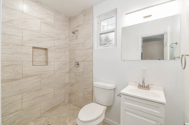 a white toilet sitting next to a bathroom sink