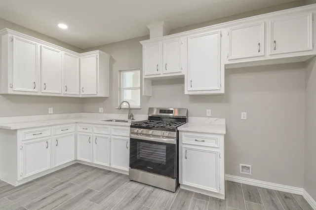 a kitchen with granite countertop white cabinets and white appliances