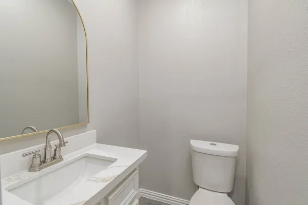 a bathroom with a sink a toilet and mirror