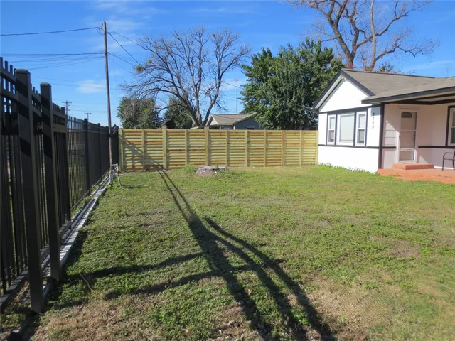 a view of a backyard with wooden fence