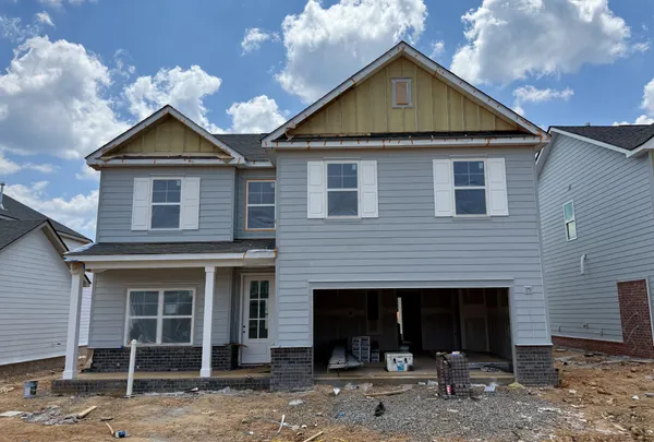 a front view of a house with yard garage and barbeque