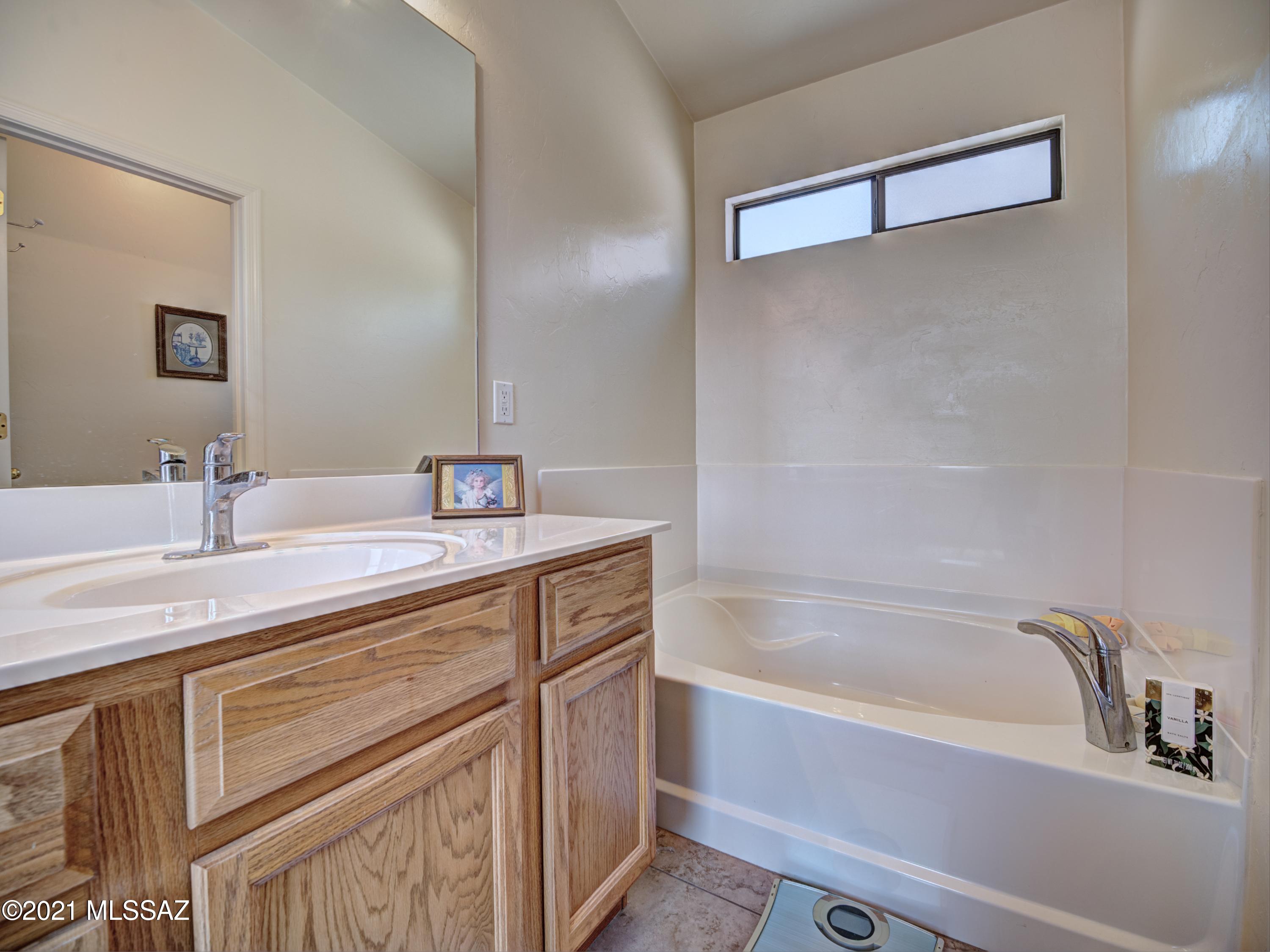 434 Colorado Court Rio Rico, AZ 85648 - Photo 22 of 29 a bathroom with a tub sink and mirror
