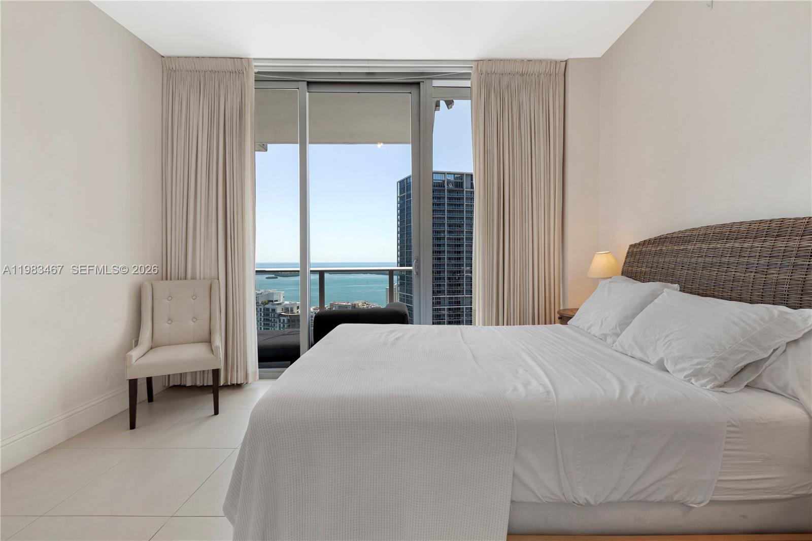 200 Biscayne Blvd Way, Unit 4907 Miami, FL 33131 - Photo 15 of 18 a bedroom with a bed a chair and a large window